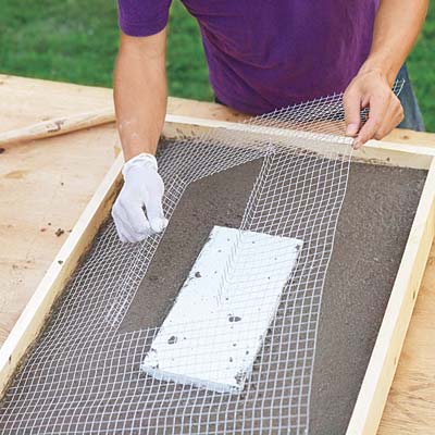 Mark Powers places wire mesh on top of the curing hypertufa mix