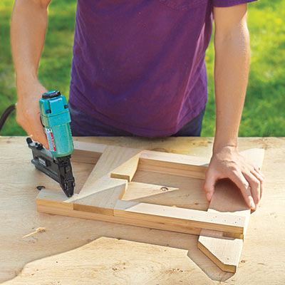 Mark Powers fastens the sides of the hypertufa table together with a pneumatic nail gun