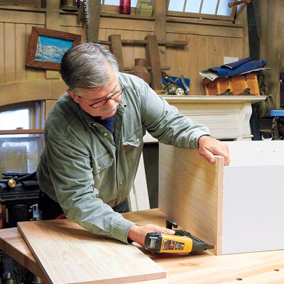 Tom Silva attaches the base to the bookcase