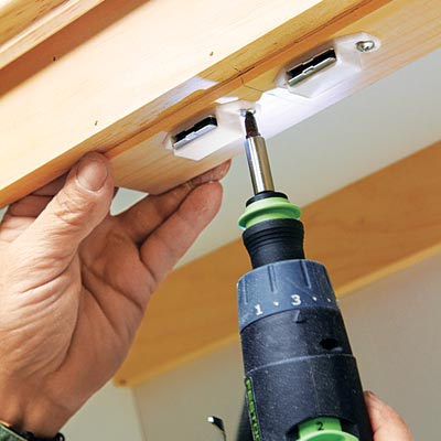 Tom Silva attaches door catches to the shutter doors