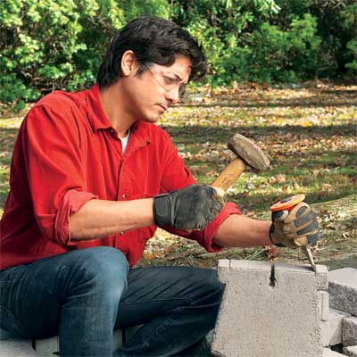 person fitting blocks to build a stone planter