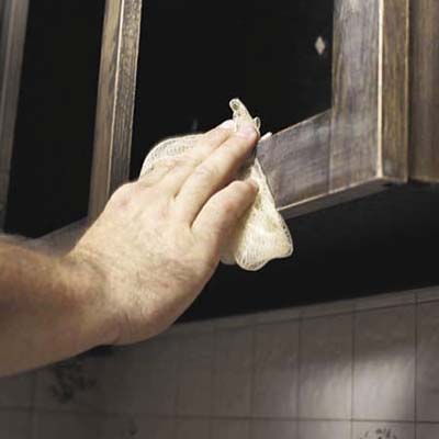 sanding the old finish on cabinet frames and wiping with a tack cloth