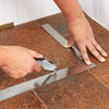 cutting a patch of vinyl flooring to fix a tear