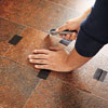 using a vinyl patch to outline and cut away a damaged portion of vinyl flooring