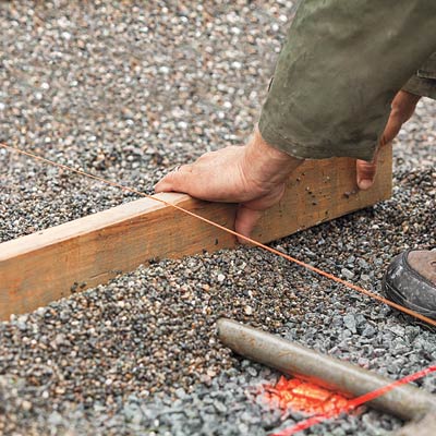 screeding the gravel to keep it flat for a new driveway