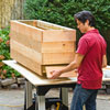 Mark Powers fastens bottom row of 1x6 boards to the planter