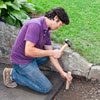 checking the depth of an area of removed driveway