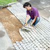laying more cobblestone mats in the driveway apron