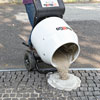 spreading grout onto a cobblestone driveway apron