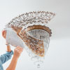 peeling off the stencil to reveal a faux ceiling medallion