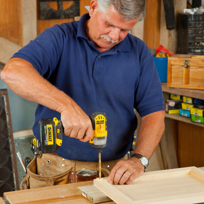 Tom Silva drilling a pilot hole in an artists' wood panel