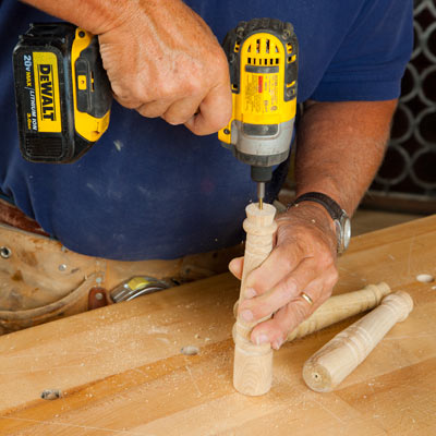 drilling a pilot hole in the bottom of a table leg