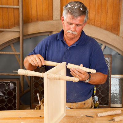 Tom Silva attaching table legs to the middle tray