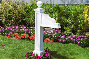 Address Plaque Post installed in a flower bed in front of a house
