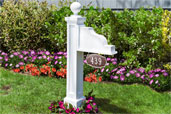 Address Plaque Post installed in a flower bed in front of a house