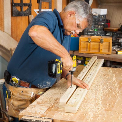 Tom Silva uses a paddle bit to enlarge the pilot holes to the size of the baluster pins