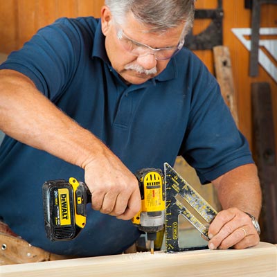 Tom Silva drills pilot holes into the bottom rail