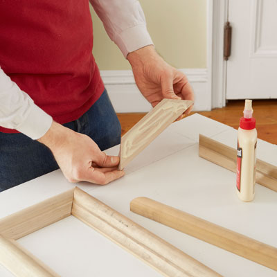 applying glue to the backs of the moldings