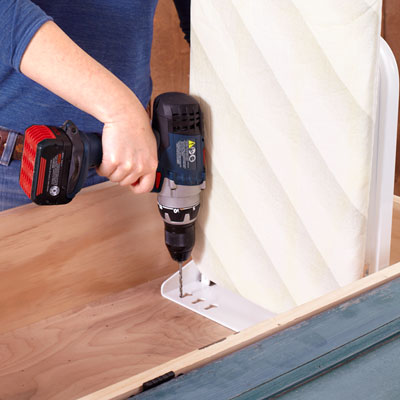 securing an ironing board to the inside of the cabinet