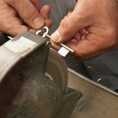 filing down the bit on the key to match the keyhole in the existing lock, making a new skeleton key for an old mortise door lock