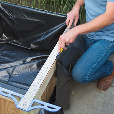 cutting the pond liner to fit with a straightedge and a utility knife
