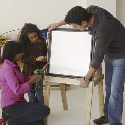 Family mounting the boards to build an easel