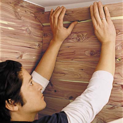 Hands placing the topmost course to the wall