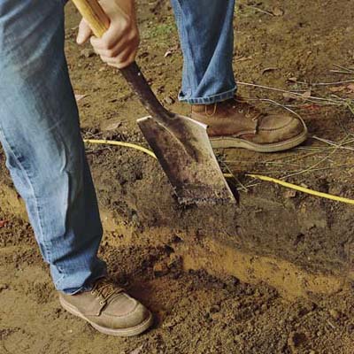 excavating soil to build a brick walkway