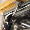 Screws are drawn in the mounting brackets to fasten dshwasher underside of the countertop 