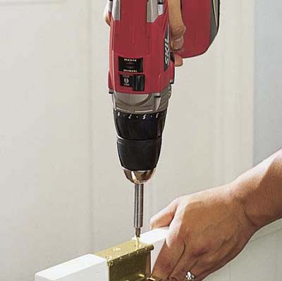 Screwing the hinges on the shutters.