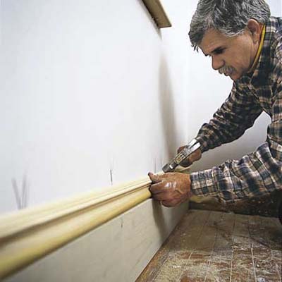 Tom Silva installing baseboard