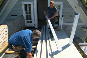 on the roof deck, Tom Silva and Kevin O'Connor install cellular PVC porch boards