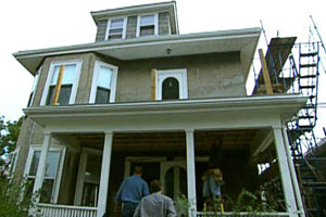 Norm Abram and Kevin O'Connor walk up the front steps of the East Boston house project