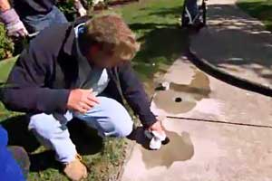 an experienced landscaper mudjacking or lifting a sagging concrete walkway slab