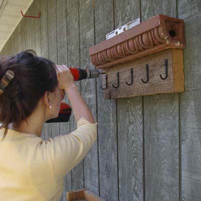 fasten cornice turned into garden tool holder to wall